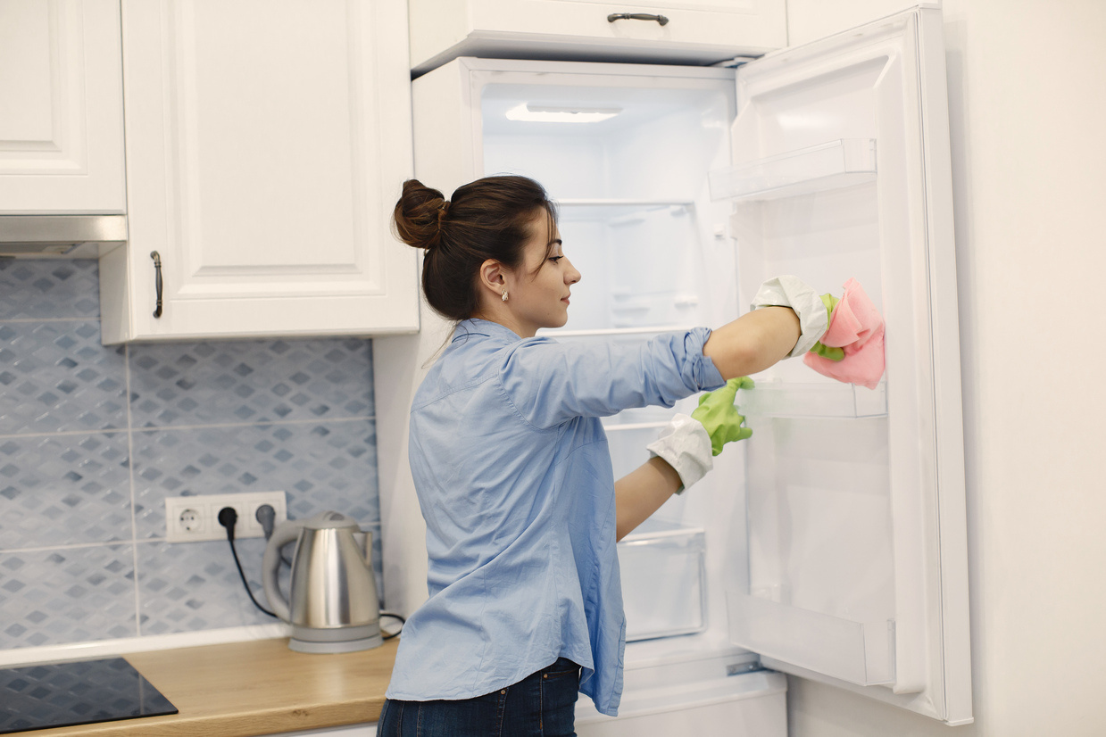 an image of a person maintaining and cleaning the refrigerator